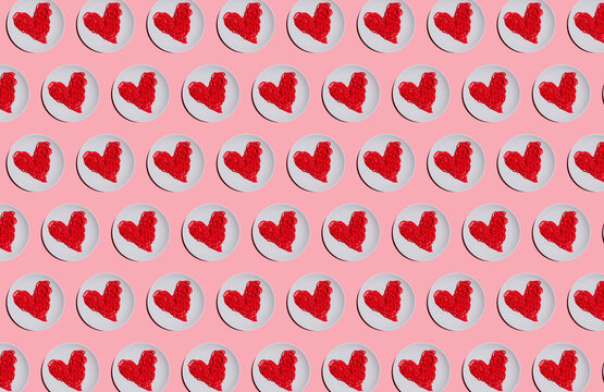 Pattern of plates with red-colored heart-shaped spaghetti against pink background