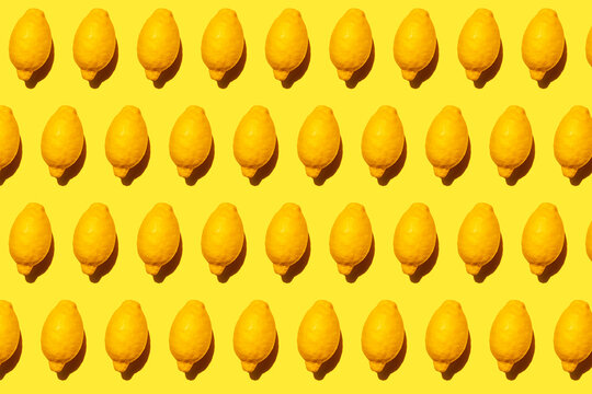 Seamless pattern of ripe lemons against yellow background