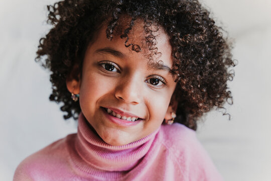 Portrait of smiling little girl wearing pink turtleneck pullover