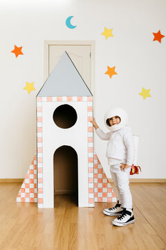 Girl wearing costume and playing astronaut at rocket