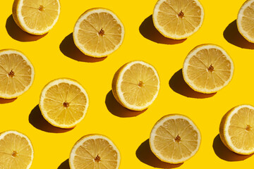 Seamless pattern of fresh halved lemons against yellow background