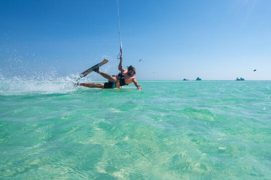 kiter does a difficult trick on a background of transparent water and blue sky