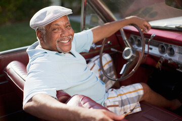 Smiling older man driving convertible - obrazy, fototapety, plakaty