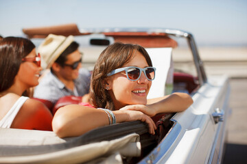 Smiling woman leaning out convertible