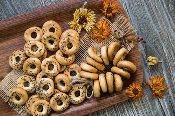 bagels with poppy seeds lie on a tray decorated with flowers