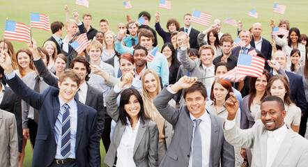 Fototapeta na wymiar Portrait of smiling business people waving American flags overhead