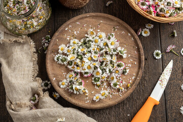 Fresh daisy flowers on a cutting board, top view