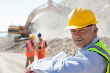 Businessman wearing hard hat in quarry
