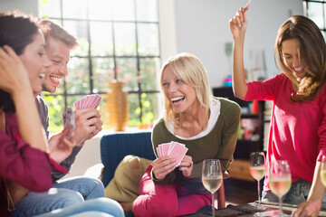 Friends playing card game in living room