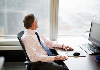 Businessman gazing out window in office