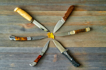 set of hunting knives on wooden background