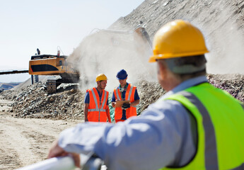 Businessman watching workers in quarry - obrazy, fototapety, plakaty
