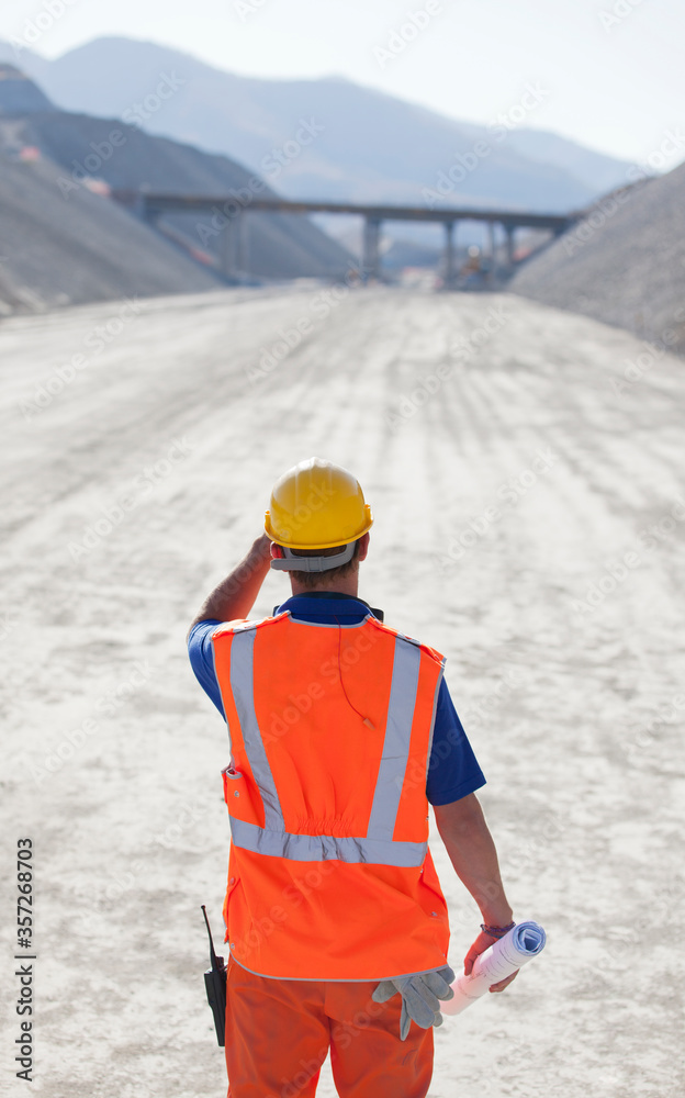 Wall mural worker standing on road in quarry