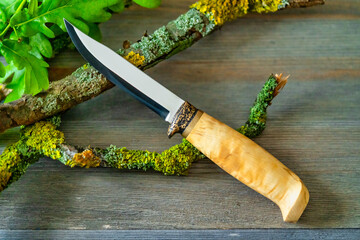 hunting knife lies on wooden table