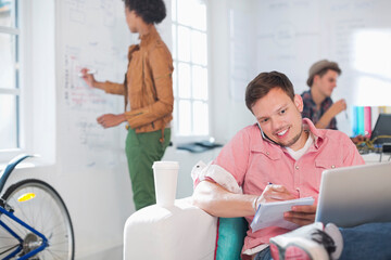 Businessman taking notes on phone in office