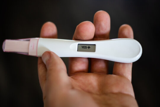 Close up image of digital positive pregnancy test with uniform background