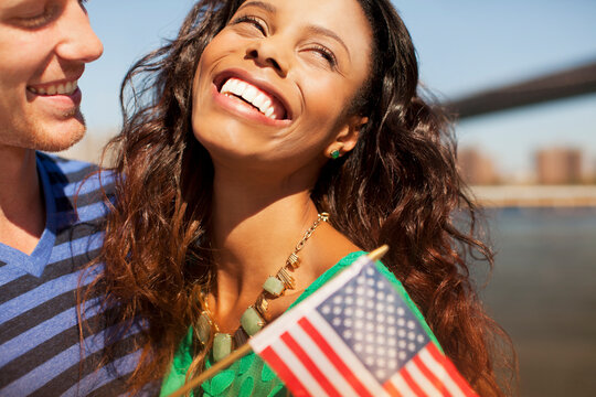 Couple with American flag by city cityscape - Powered by Adobe
