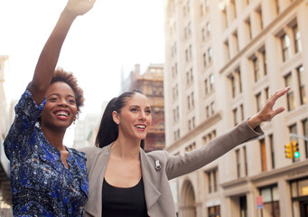 Women hailing taxi on city street