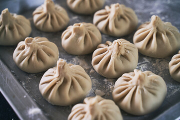 Pile of homemade raw khinkali delicious Georgian dumplings on home kitchen table