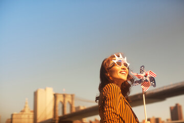 Woman novelty sunglasses with pinwheel by urban bridge