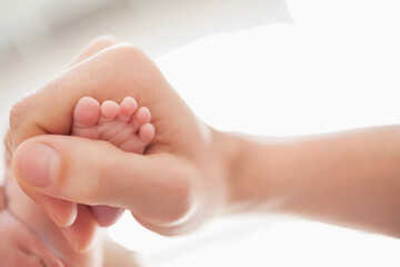 Mother cradling newborn baby's foot