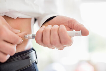 Man giving himself injection in stomach