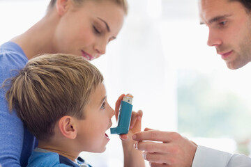 Parents giving son asthma inhaler - obrazy, fototapety, plakaty