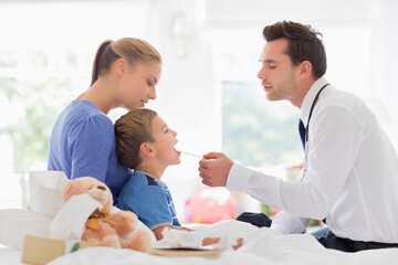 Fototapeta premium Doctor taking son's temperature