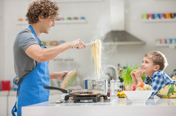 Father and son cooking in kitchen