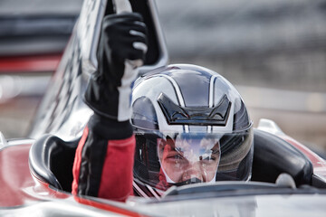 Racer giving thumbs up from car on track © Martin Barraud/KOTO