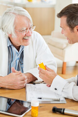 Obraz premium Doctor giving medication to older patient at house call