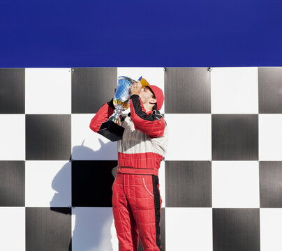 Racer kissing trophy at award ceremony