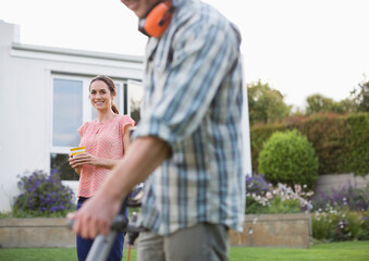 Woman watching man work in garden