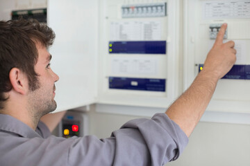 Naklejka na ściany i meble Electrician examining control panel