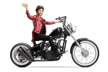 Plakat Young woman biker with a helmet and a leather jacket riding a chopper and waving