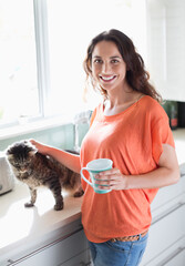 Woman petting cat in kitchen