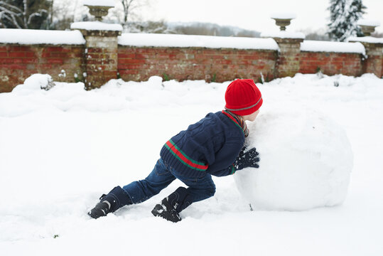Boy making snowman outdoors