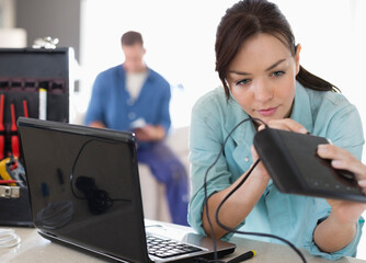 Female electrician working on laptop in home