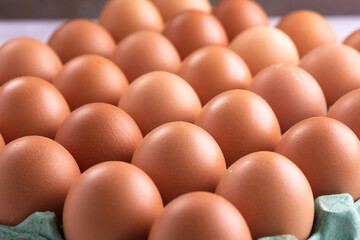 Box of red eggs on a rustic white table. Top view.