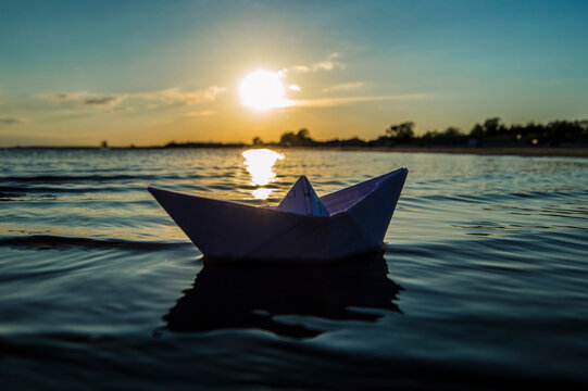 paper boat in the evening at sea sunset