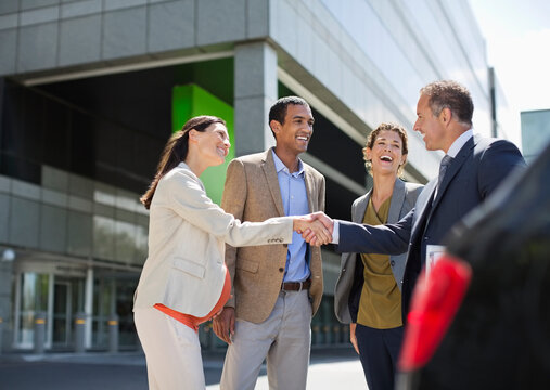 Business people shaking hands outdoors - Powered by Adobe