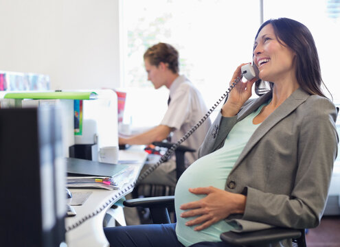 Pregnant businesswoman talking on telephone