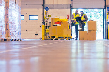Workers checking boxes in warehouse - obrazy, fototapety, plakaty