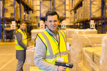 Worker scanning boxes in warehouse - obrazy, fototapety, plakaty