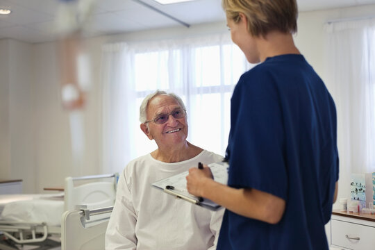 Nurse Talking With Older Patient In Hospital