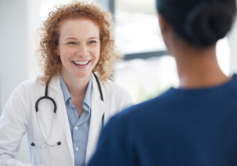 Doctor and nurse talking in hospital hallway