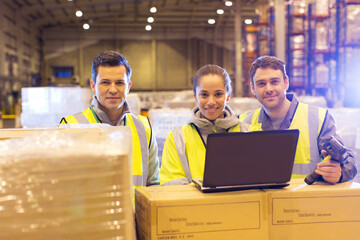 Workers using laptop in warehouse - obrazy, fototapety, plakaty