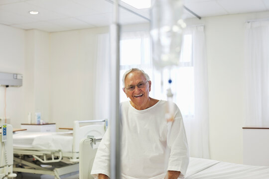 Older Patient Sitting On Bed In Hospital Room