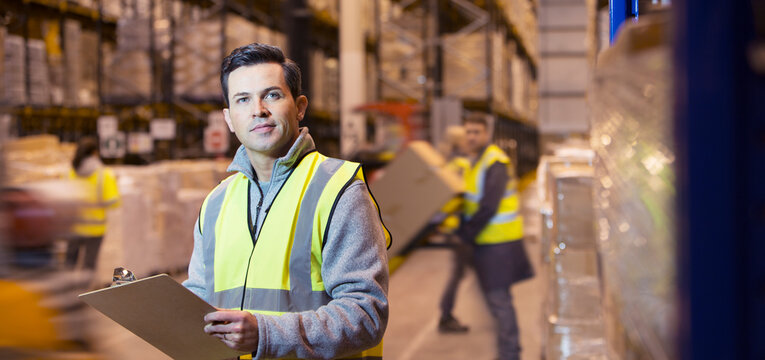 Worker using clipboard in warehouse - Powered by Adobe