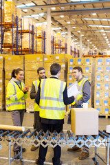 Businessman and workers talking in warehouse
